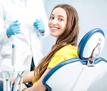 Image of lady sitting on dentist chair with smilling face