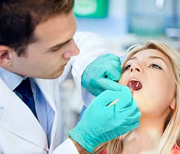 Image of a Dentist checking Patient's mouth